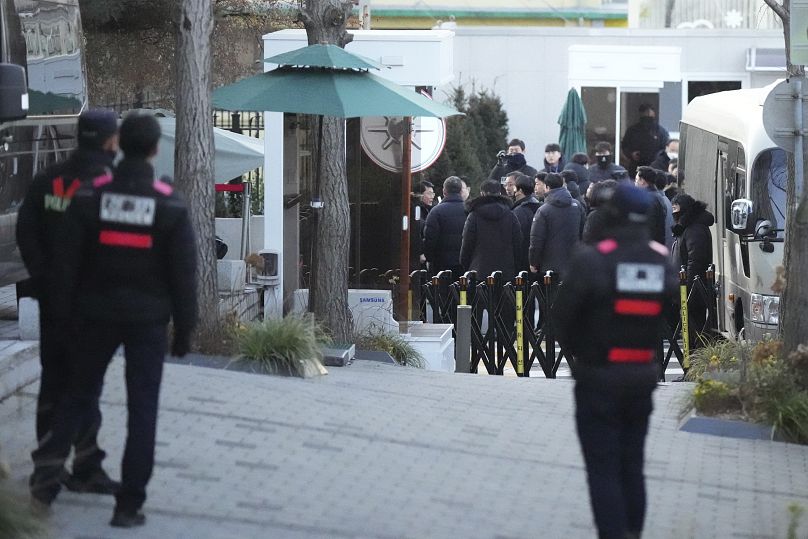Des policiers arrivent à la porte de la résidence présidentielle à Séoul avec un mandat d'arrêt contre le président Yoon Suk Yeol, le 3 janvier 2025.