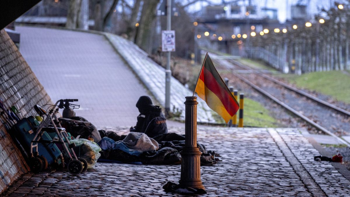 A German national flag waves near a homeless encampment under a bridge, in Frankfurt, Germany. 27 January 2025.