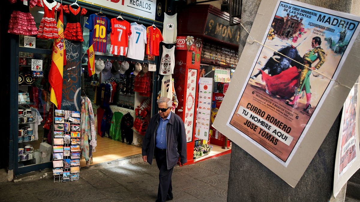 File picture of a man walking past a souvenir shop in the centre of Madrid