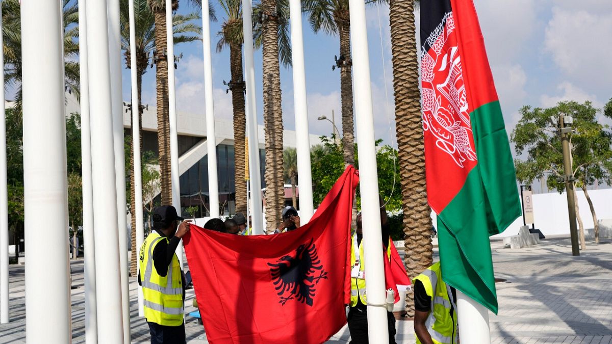 Flag of Albania, left, and the old flag of Afghanistan, are adjusted ahead of the COP28 U.N. Climate Summit, Wednesday, Nov. 29, 2023, in Dubai, United Arab Emirates.