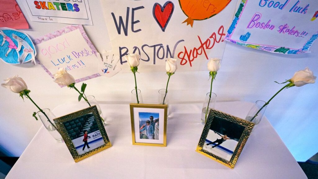 Six white roses and photographs of victims are displayed at The Skating Club of Boston, Thursday, Jan. 30, 2025, in Norwood, Mass.