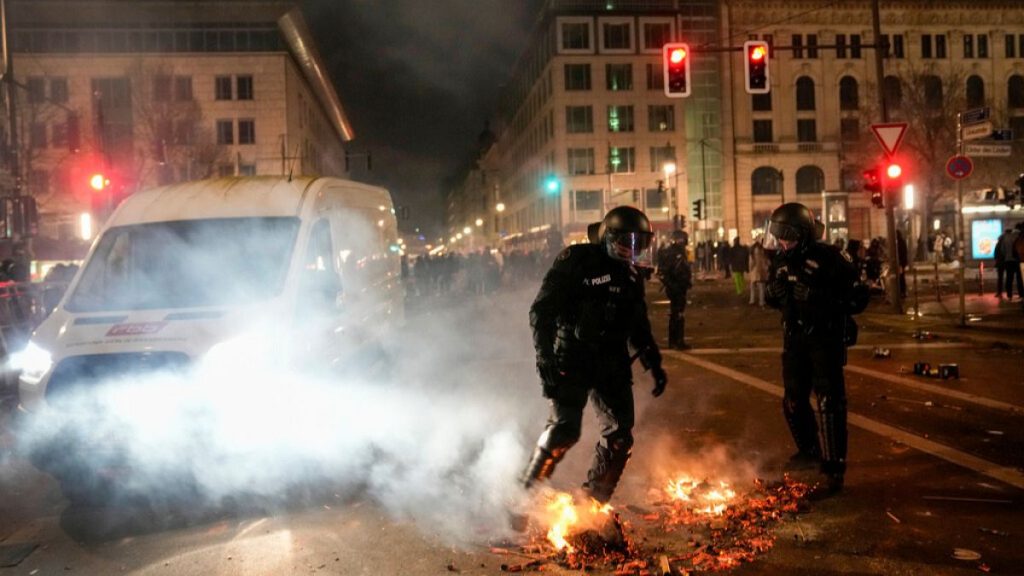 Police officers put out the fire in the streets after the fireworks for the New Year