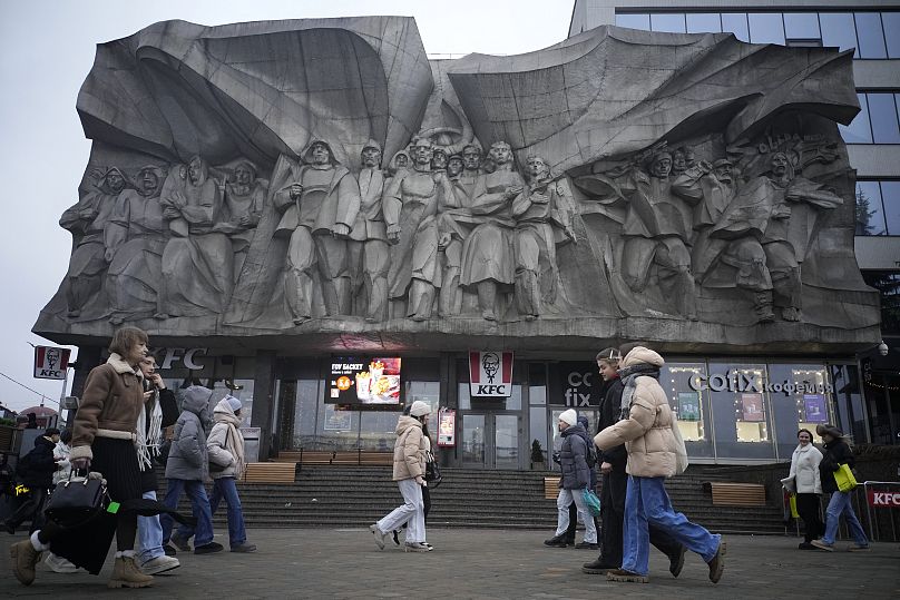 Des gens marchent à côté d’un bas-relief de solidarité à Minsk, le 25 janvier 2025