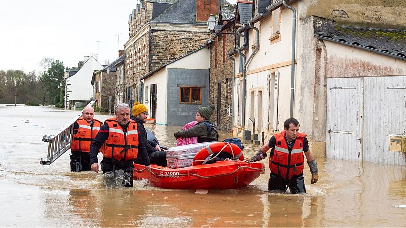 Les secouristes tirent des résidents sur un petit bateau après que la tempête Herminia ait déclenché des averses sur Ille -t-Vilaine.