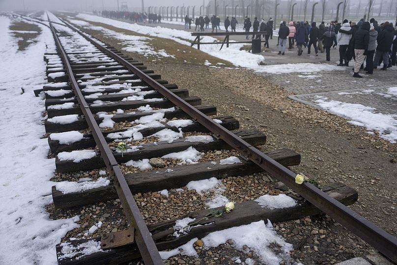 Des visiteurs marchent le long de la voie ferrée autrefois utilisée pour transporter les Juifs de toute l'Europe vers Auschwitz, le 23 janvier 2025.