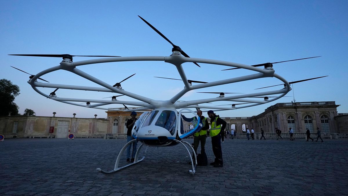 People gather at a Volocopter aircraft before a test flight on the last day of the 2024 Olympics at the 2024 Summer Olympics, Sunday, Aug. 11, 2024, in Versailles, France.