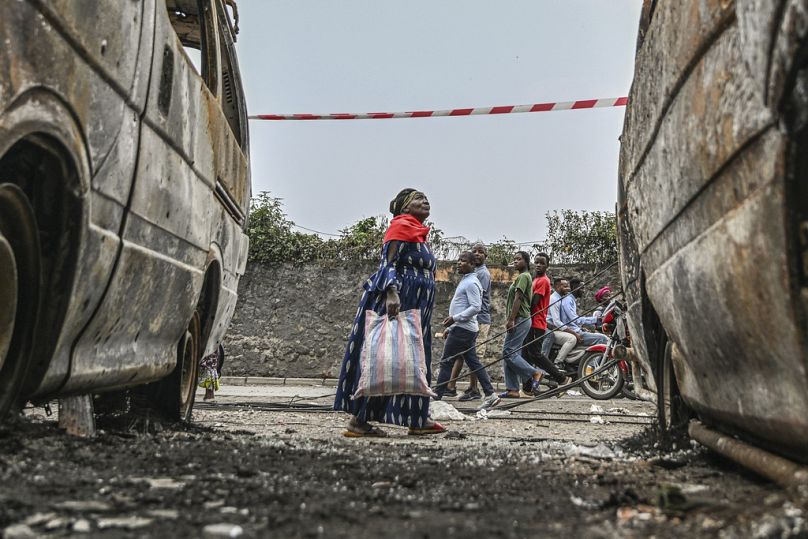 Les résidents marchent par véhicules carbonisés à Goma, République démocratique du Congo, vendredi 31 janvier 2025. (AP Photo / Moses Sawasawa)