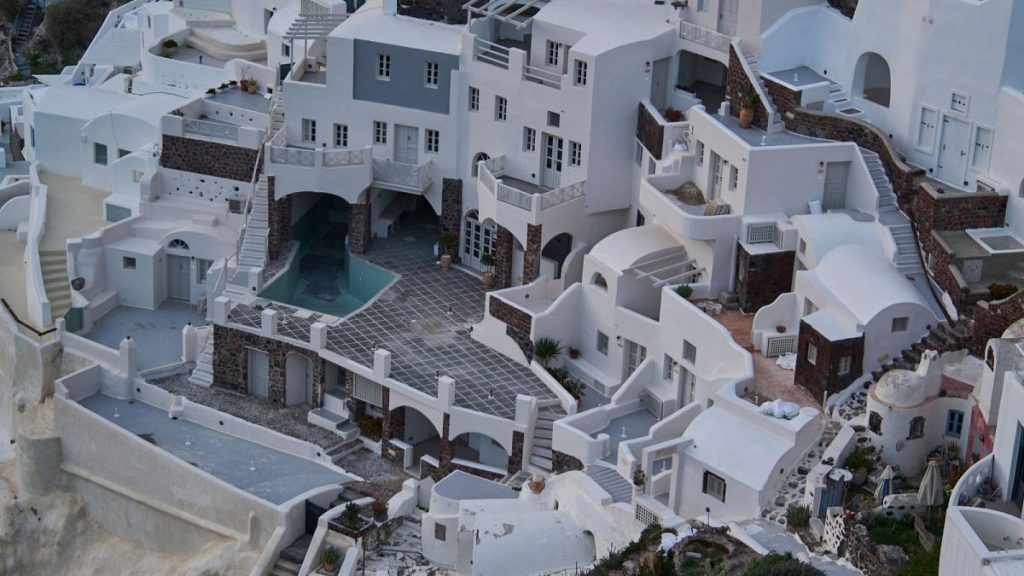 An empty swimming pool is seen in a group of clifftop buildings in the town of Oia on the earthquake-struck island of Santorini, Greece.