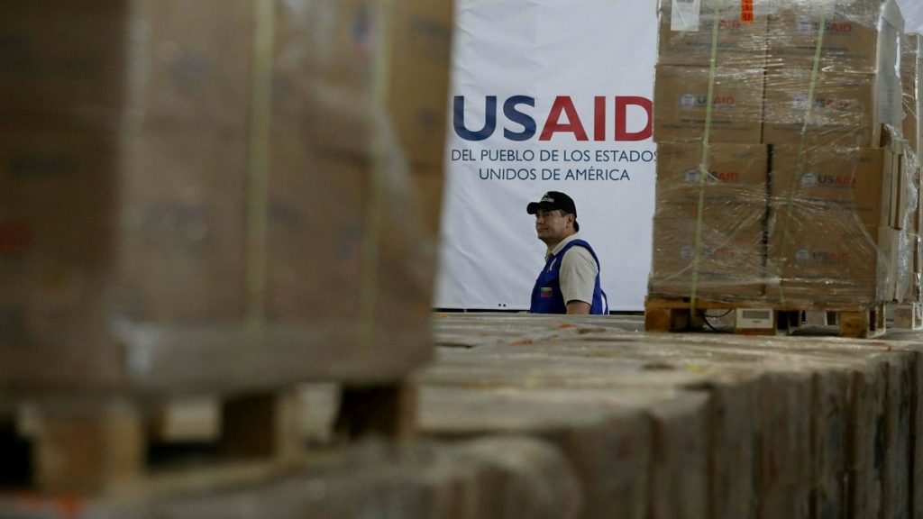 A man walks past boxes of USAID humanitarian aid at a warehouse at the Tienditas International Bridge in Colombia, 21 February, 2019