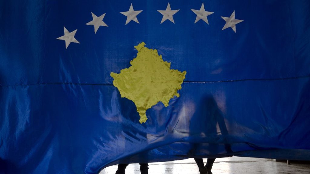 Students lift the flag of Kosovo during an independence celebration ceremony at a school in Sllovi, 16 February, 2018