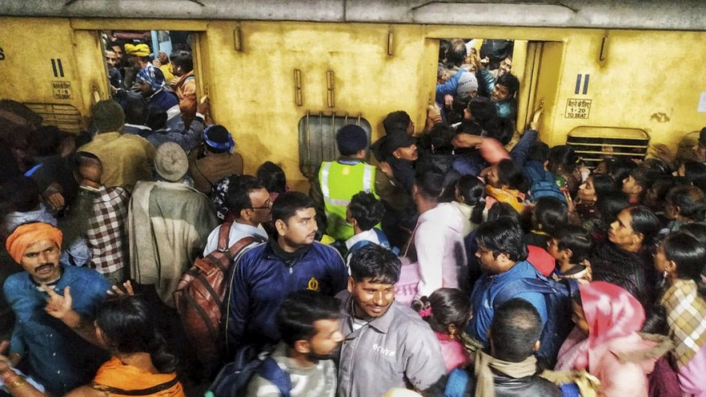 Passengers jostle with each other to board a train at the New Delhi Railway station, in New Delhi, India, Thursday, Feb.15, 2025. (AP Photo)
