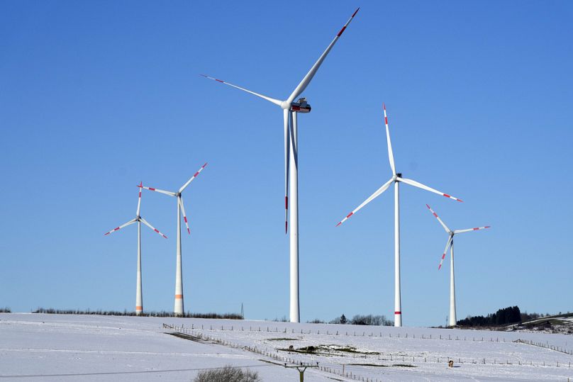 Les éoliennes sont représentées sous un ciel bleu par une froide journée d'hiver à Brilon, en Allemagne.