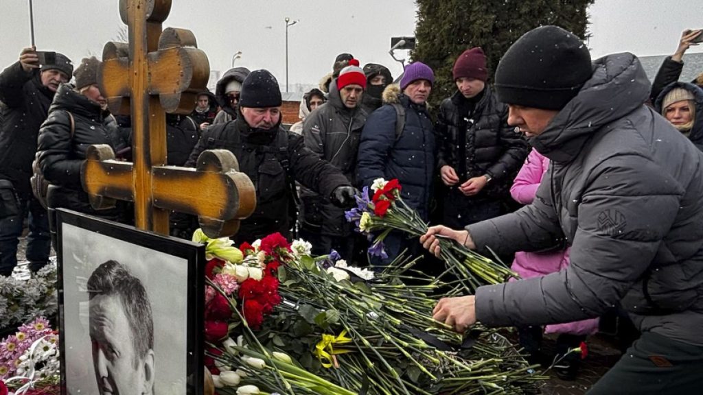 People lay flowers at the grave of Russian opposition leader Alexei Navalny, a year after his death, at the Borisovskoye Cemetery in Moscow, on Sunday, Feb. 16, 2025.