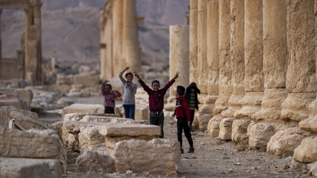 Children play, with one raising the V sign, at the ancient city of Palmyra, Syria.