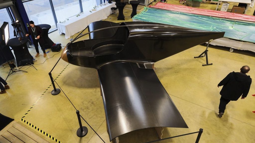 The Climate Impulse, a plane powered by liquid hydrogen, is displayed in a hangar in Les Sables d