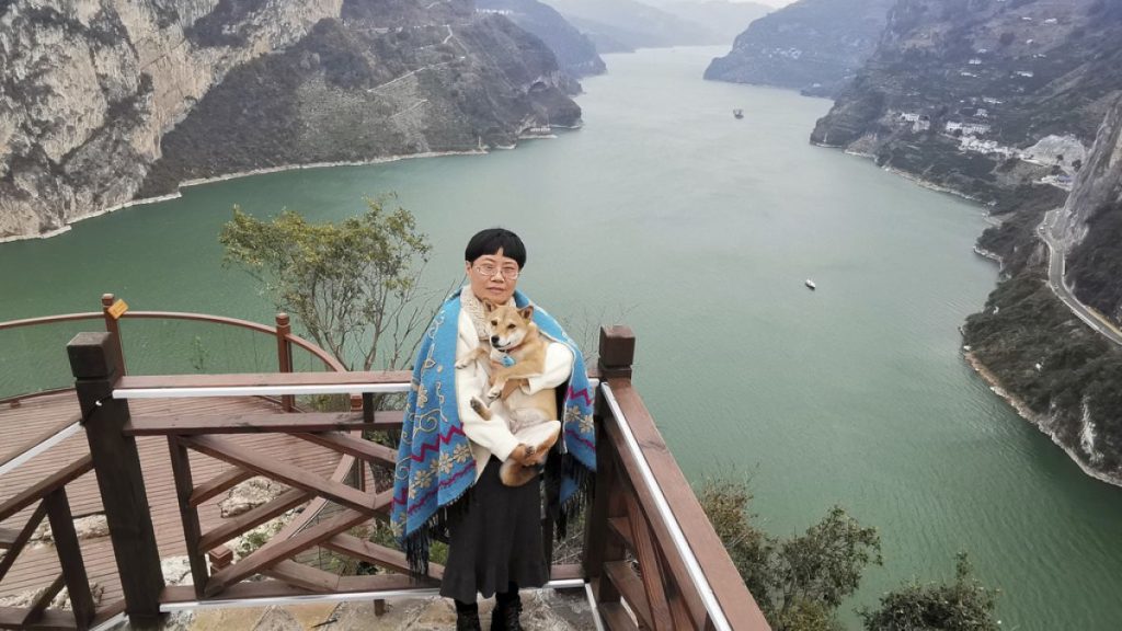 Tan Yuanyi, Zhang Yali poses for photos by a mountain in Yichang, China that looks like a puppy