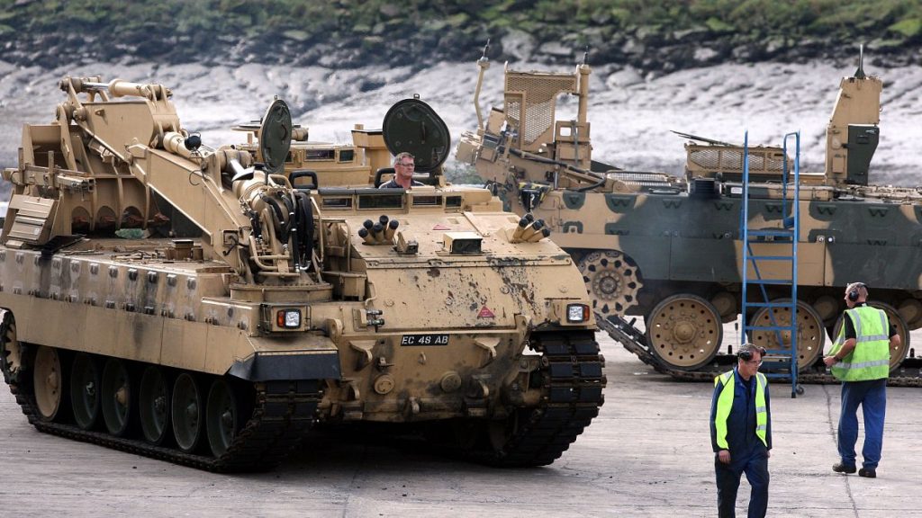 BAE employees move an armoured vehicle at the BAE Systems plant in Newcastle, England. 27 Sept. 2011.