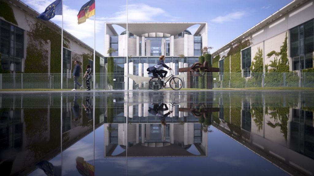 File picture of the Chancellery with the office of the German chancellors reflected in a puddle from a sprinkler on a sunny day in Berlin