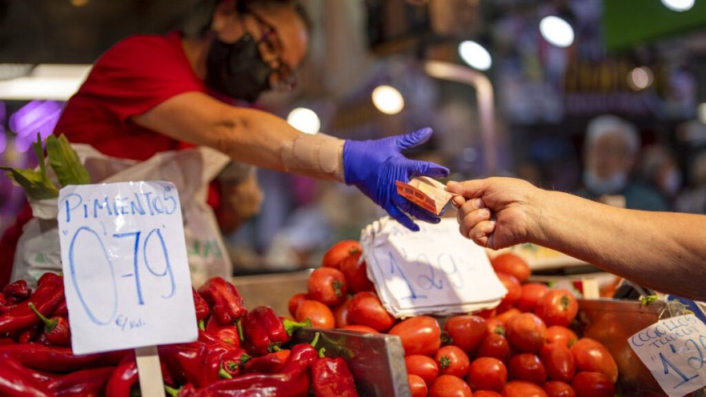 A customer pays for vegetables at the Maravillas market in Madrid, Spain, May 12, 2022.