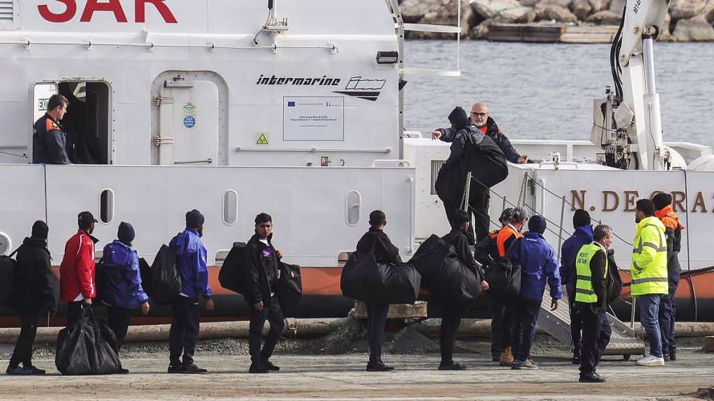 Migrants board an Italian Coast Guard vessel as part of a transfer operation from the asylum processing centers in Albania back to Italy following a court decision in Rome, at