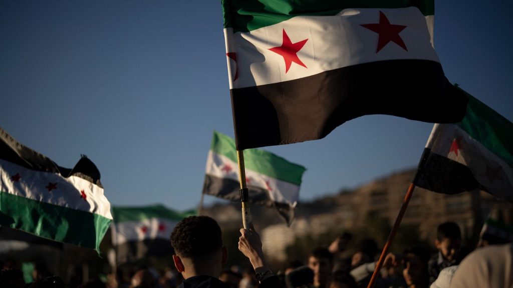 Syrians wave "revolutionary" Syrian flags during a celebratory demonstration following the first Friday prayers since Bashar Assad