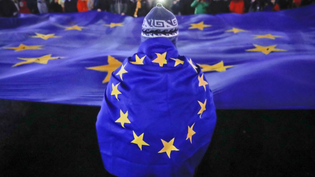 FILE: People hold a large European Union flag during a protest joined by hundreds in Bucharest, Romania, Sunday, Dec. 3, 2017.