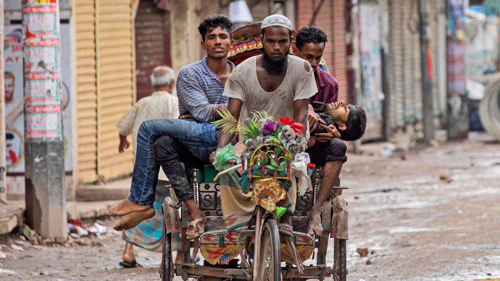 People carry an injured protester in a cycle rickshaw to a hospital after he was shot at by the police during a protest against Prime Minister Sheikh Hasina.