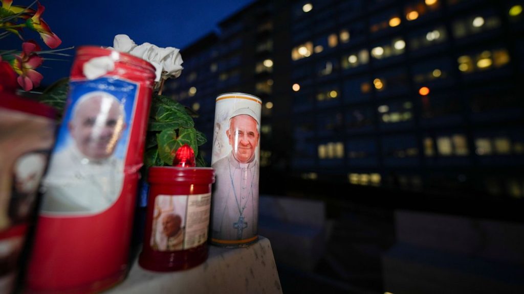 Candles with pictures of Pope Francis are laid under the statue of late Pope John Paul II outside Agostino Gemelli Polyclinic in Rome.