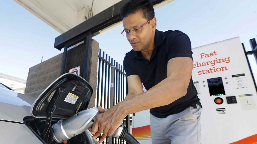 Darshan Brahmbhatt, plugs a charger into his electric vehicle at the Sacramento Municipal Utility District charging station in Sacramento, 17 Sept 2015