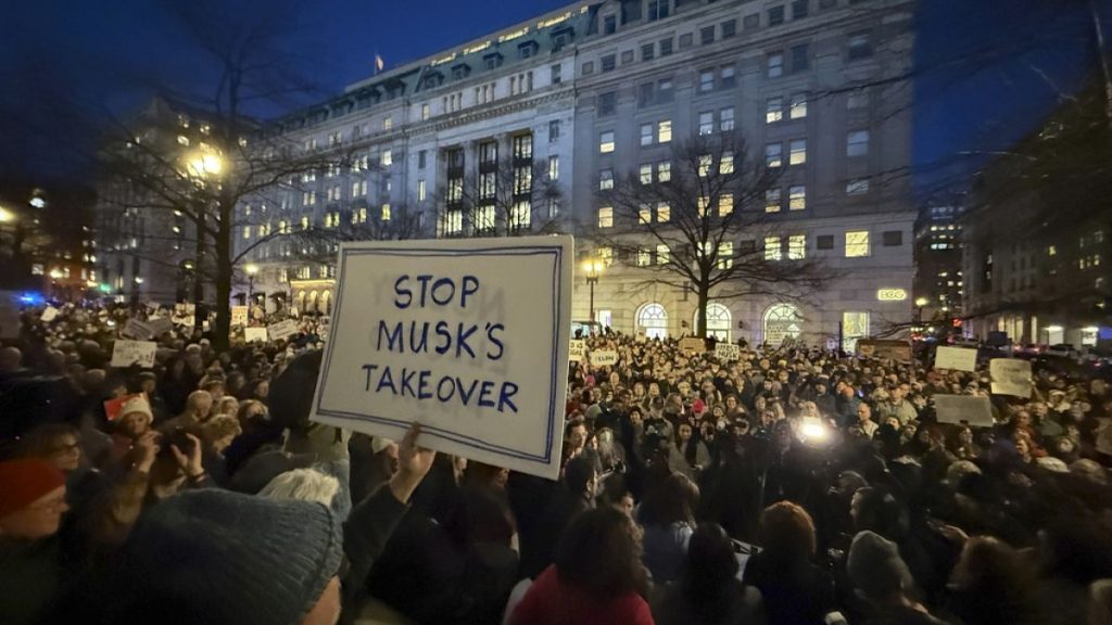 People protest during a rally against Elon Musk outside the Treasury Department in Washington, Tuesday, Feb. 4, 2025. (AP Photo/Jose Luis Magana)