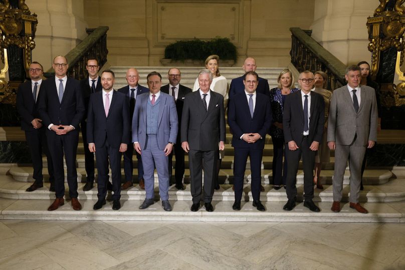 Le roi Philippe de la Belgique, le front central et le nouveau Premier ministre belge Bart De Wever, avant au centre à gauche, posent avec des ministres après une cérémonie de serment pour le nouveau gouvernement
