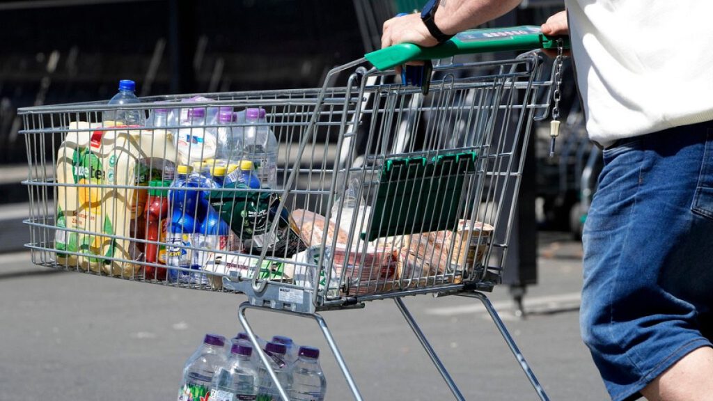 A man pushes a shopping cart outside a supermarket, Wednesday, May 31, 2023.