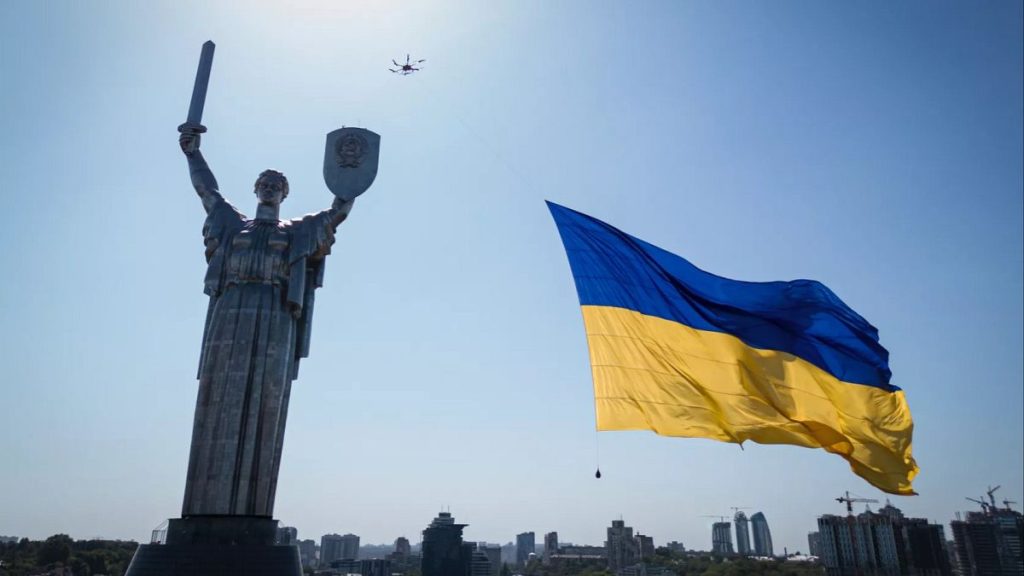 A drone carries a big national flag in front of Ukraine