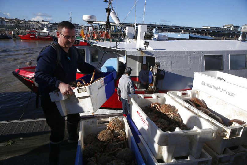 Un pêcheur français transporte des boîtes de crabes dans le port de Boulogne-sur-Mer, dans le nord de la France.