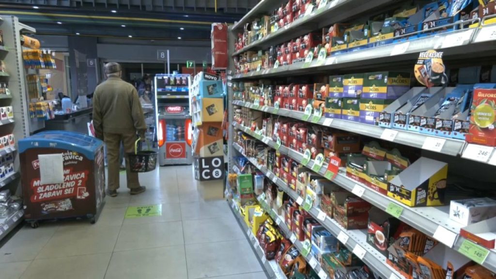 A man is standing in the isle as he is shopping in a grocery store in Serbia.