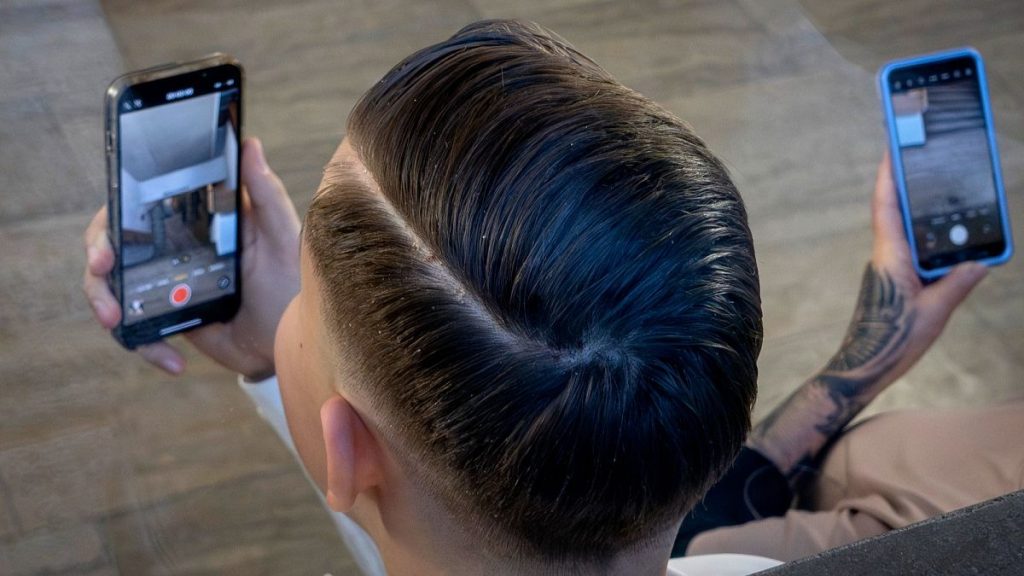 A man films with his mobile as he attends an AfD election campaign in Neu Isenburg near Frankfurt, 1 February 2025