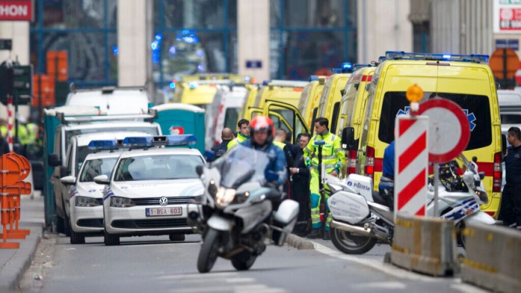 A police motorcycle rides by ambulances at a staging station near a metro after an explosion in Brussels on Tuesday, March 22, 2016.