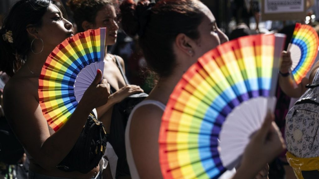 People holding rainbow-colored fans gather in Buenos Aires, Argentina, Saturday, Feb. 1, 2025, during a protest against President Javier Milei’s speech at the WEF.