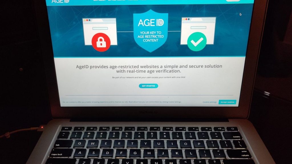 A laptop screen displaying the website for AgeID, an age verification system.