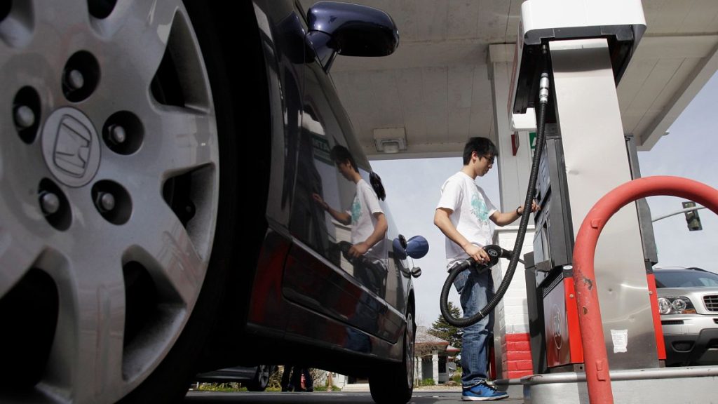 A motorist fuels up at a gas station. 7 March 2011.