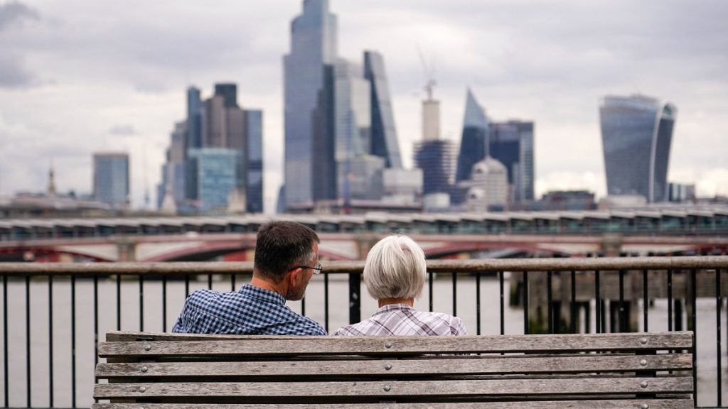 Two people sit on a bench in London in September 2023.