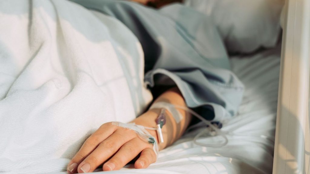 A patient lies in a hospital bed.