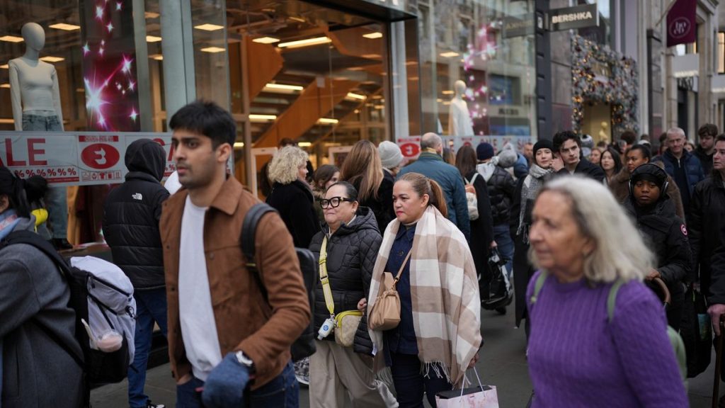 File photo of people passing a shop advertising for post-Christmas sales on Oxford Street in London, Monday, Dec. 30, 2024.