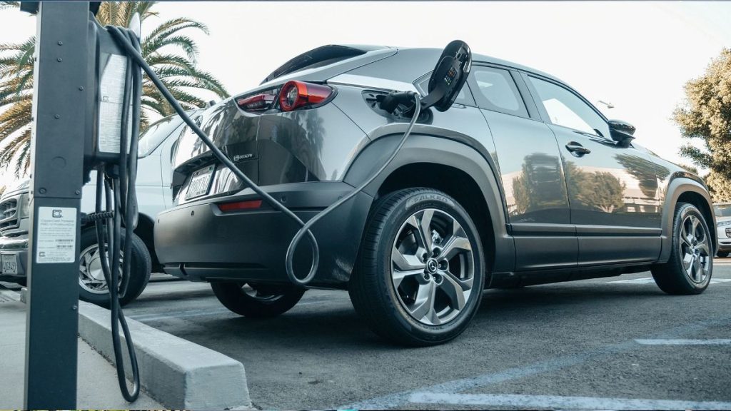Grey electric car parked on a charging bay.