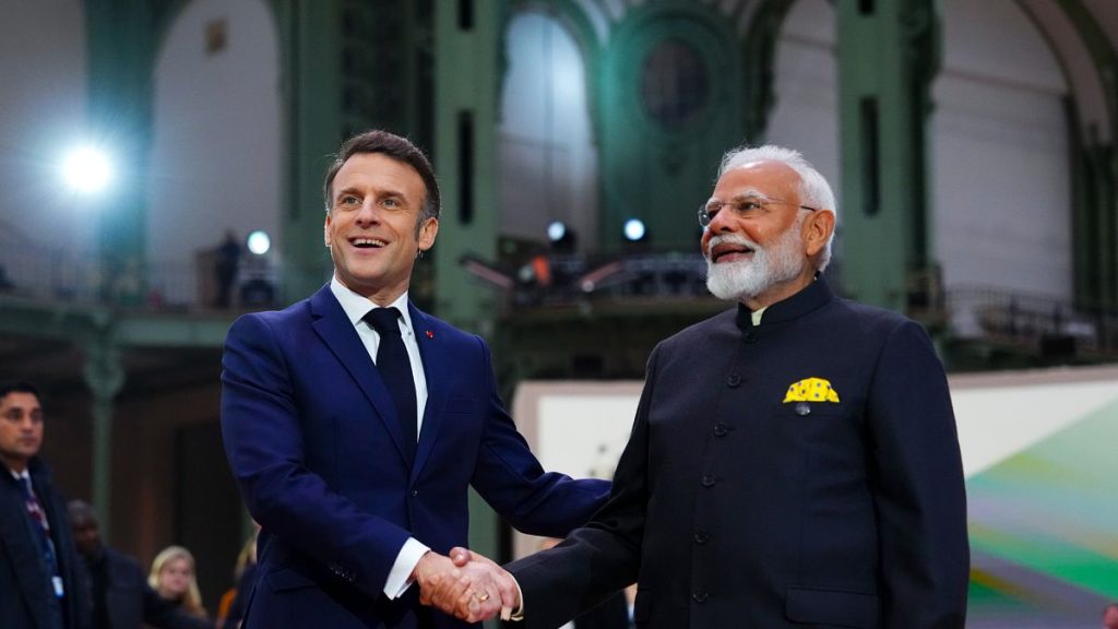 French President Emmanuel Macron shakes hands with India