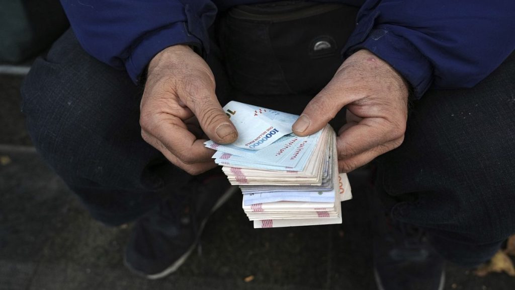 A street money exchanger counts Iranian banknotes at a commercial district in downtown Tehran, 23 December, 2022