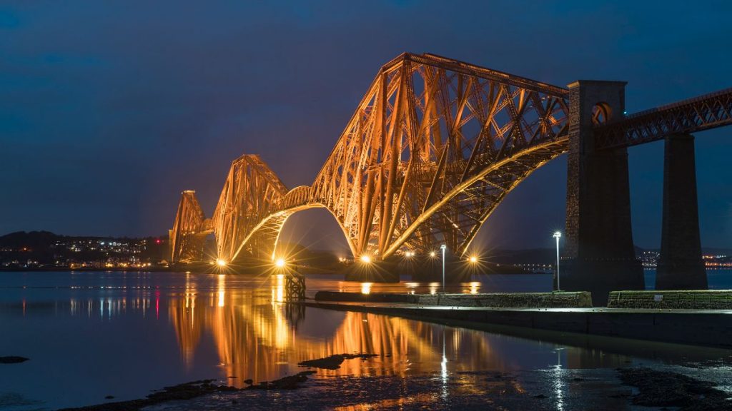 The historic Forth Rail Bridge in Scotland lit up at night