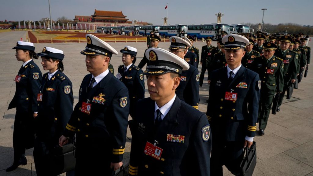Military delegates march in formation to the Great Hall of the People to attend a preparatory session of the National People