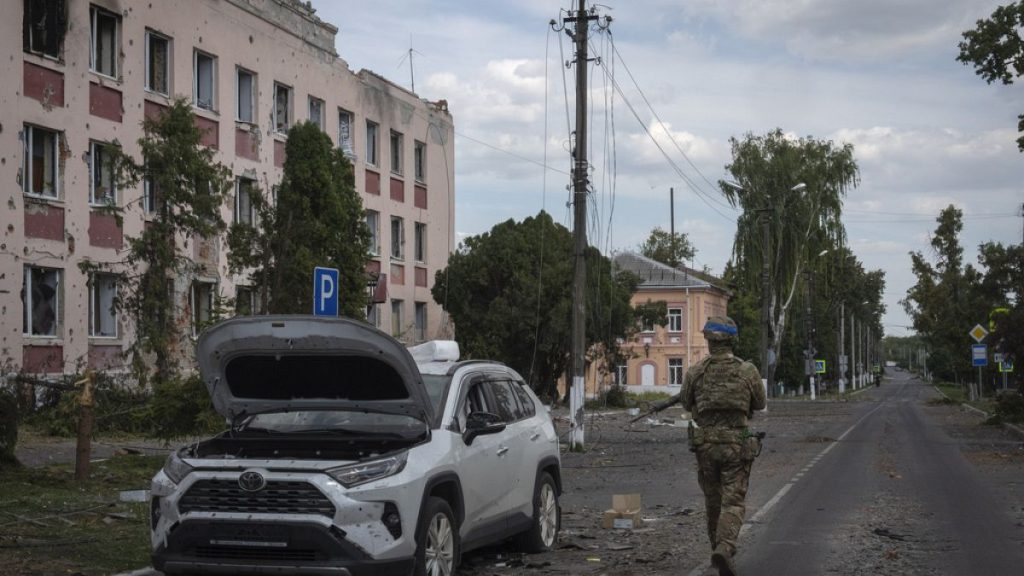FILE - A Ukrainian soldier walks past a building in Sudzha, Kursk region, Russia, on Aug. 16, 2024.