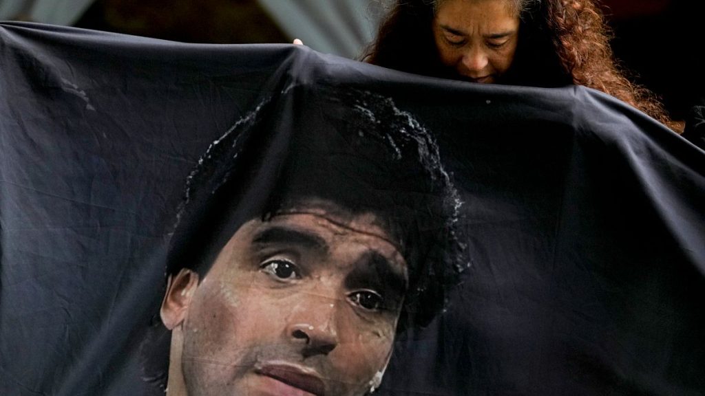 A Maradona fan holds his image outside the court where his medical team faces trial for alleged homicide by negligence, in Buenos Aires, 11 March 2025